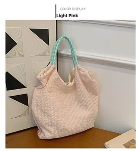Gros plan du sac cabas plissé rose avec anses tressées à carreaux vert menthe