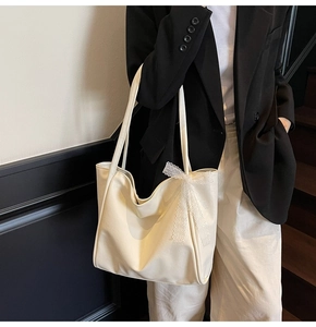 Detail of soft cream white tote bag with elegant lace bow tied on the handle