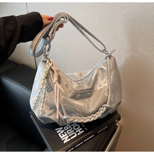 Detail of silver metallic tote bag with woven rope decor and adjustable shoulder strap