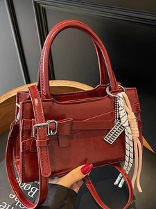 Borsa a mano rossa lucida con fiocco e ciondolo di perline, scena di stile di vita
