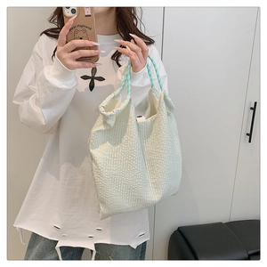 Gros plan du sac cabas plissé vert clair avec des poignées à carreaux bleus et blancs