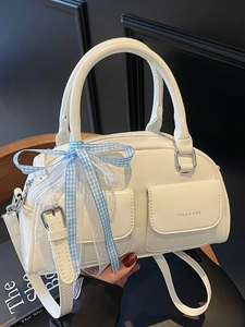 White Boston handbag with glossy finish featuring front pockets and ribbon bow detail