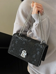 Fashionable black faux snakeskin crossbody bag with silver chain strap and metal lock