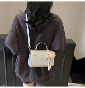 Silver metallic crossbody bag with cute bear charm and silk scarf on a model