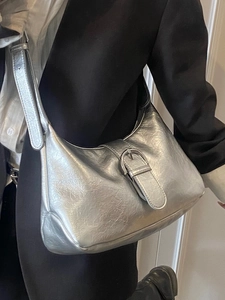 Chic silver metallic Hobo bag with wrinkled texture and buckle detail on a model