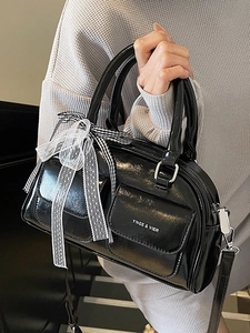 Elegant black patent leather Boston bag with decorative lace bow and utility pockets