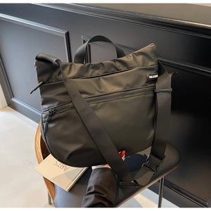 Detail of black nylon tote bag showing high-quality fabric texture and zipper pockets