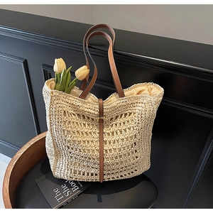 Detail of hand-woven straw tote bag showing fine hollow craftsmanship and leather handles