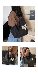 Detail of black canvas tote bag with 3D white flower accent and spacious interior