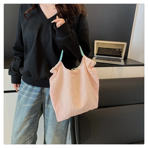 Vue détaillée du sac cabas plissé rose avec anse à carreaux verts pour un style décontracté