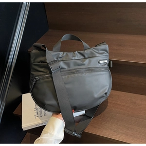 Close-up of black crescent tote bag with premium nylon texture and side rubber logo label