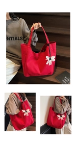 Detail of red canvas tote bag with 3D white flower charm and exterior pocket detail