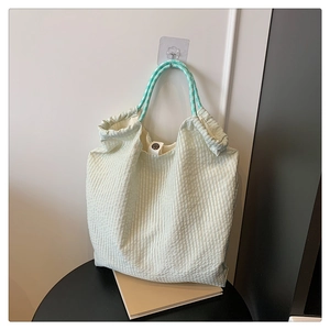 Détail du sac cabas plissé vert menthe avec anses tissées et fermoir magnétique