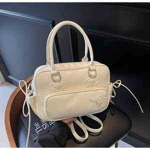 Detail of cream white Boston bag with sewn bow accents and matte PU leather texture