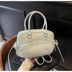 Detail view of the light blue bow Boston bag showing the smooth texture and silver zippers
