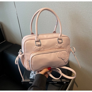 Detail shot of pink Boston bag with 3D bow decoration and matte synthetic leather
