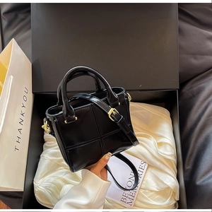 Détail du sac seau noir matelassé dans un coffret cadeau avec doublure en satin