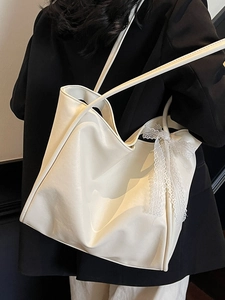 White large-capacity leather tote bag with lace bow decoration worn over the shoulder