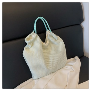 Vue détaillée du tissu en velours côtelé vert menthe et de l'anse à carreaux du sac
