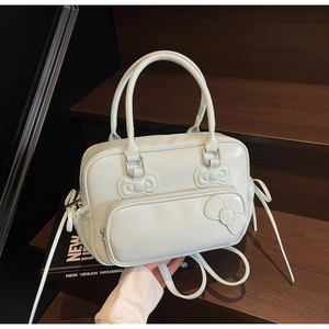 Detail of mint green bow Boston bag with glossy PU texture and embossed accents
