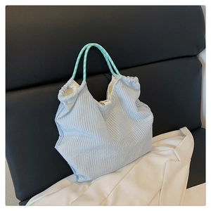 Détail du sac cabas plissé bleu clair avec poignée à carreaux verts et cordon de serrage