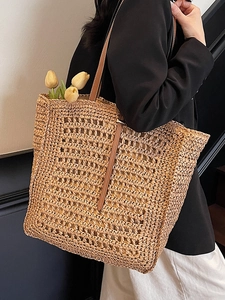 Chic beige woven straw tote bag with brown leather handles for summer beach vacations