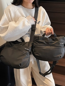 Large black nylon crescent tote bag with adjustable shoulder strap and top handle for travel
