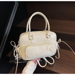 Detail view of cream PU leather bow-knot Boston bag showing dual handles and front pocket