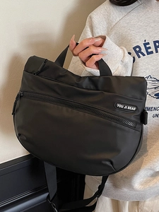 Black nylon crossbody tote bag with adjustable strap and front zipper pocket for travel