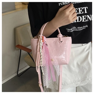 Détail du sac seau rose en cuir PU avec motifs de chiens gaufrés et nœud en dentelle
