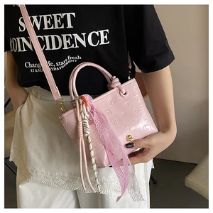 Détail du sac seau rose en PU avec motifs floraux gaufrés et breloques de perles