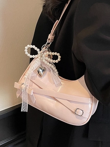 Pink patent leather shoulder bag with pearl bow, lace ribbon, and heart pendant detail