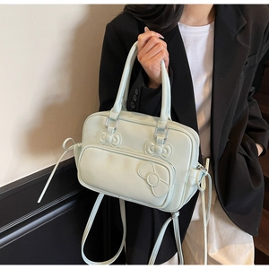 Detail of mint green PU leather bag with bow accent and drawstring side design