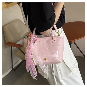 Détail du sac seau rose avec motifs de chiens gaufrés et ruban de dentelle déco