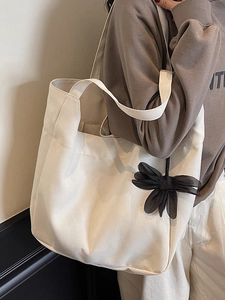 Minimalist beige canvas tote bag for women with decorative black organza bow charm