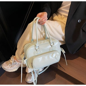 Detail showing mint green leather bag with three 3D bow pockets and double top handles