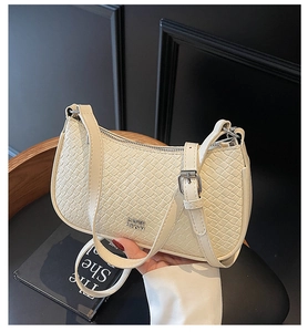 Detail of cream woven texture shoulder bag with silver hardware and adjustable strap