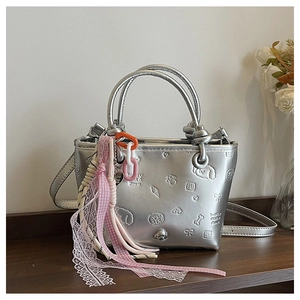 Détail du sac seau argenté avec motifs de dessins animés et charm chaîne coloré