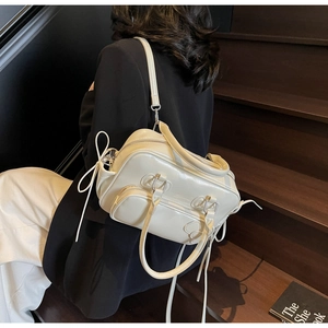 Macro shot of cream bow Boston bag with glossy patent leather finish and ribbon detail