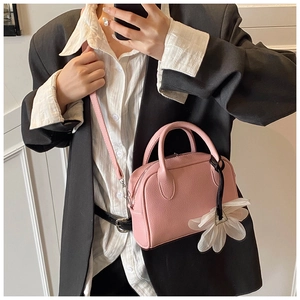 Pink lychee texture leather Boston bag detail with oversized white tulle flower charm