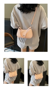 Close-up of pink textured underarm bag featuring silver logo and slim shoulder strap