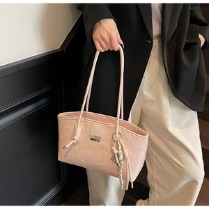 Close-up of pink tote bag featuring embossed cartoon animals and silver brand plate