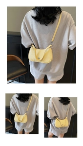 Detailed macro view of light yellow faux crocodile texture underarm bag with silver logo