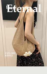 Close-up of beige hollow woven tote bag with a small white daisy flower ornament