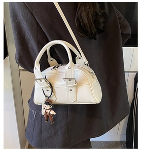 Polished white leather Boston bag with silver buckle straps and a cute cartoon charm