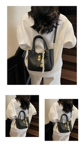 Dettaglio borsa a secchiello nera in pelle martellata con chiusura oro e foulard