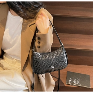 Close-up of the woven texture and metal logo detail on this black underarm shoulder bag