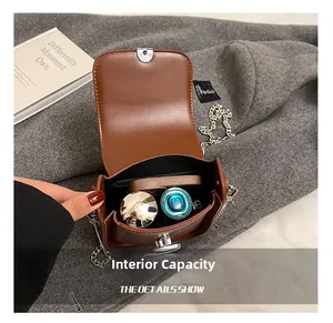 Detailed internal capacity showing caramel leather bag with silver chain and metal lock