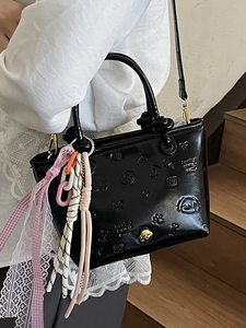 Sac seau en cuir verni noir avec motifs gaufrés et breloques colorées tendance