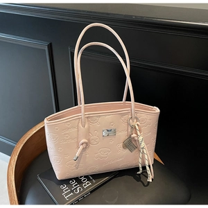 Detail of pink faux leather tote with cartoon bear embossing and abacus charm accessory